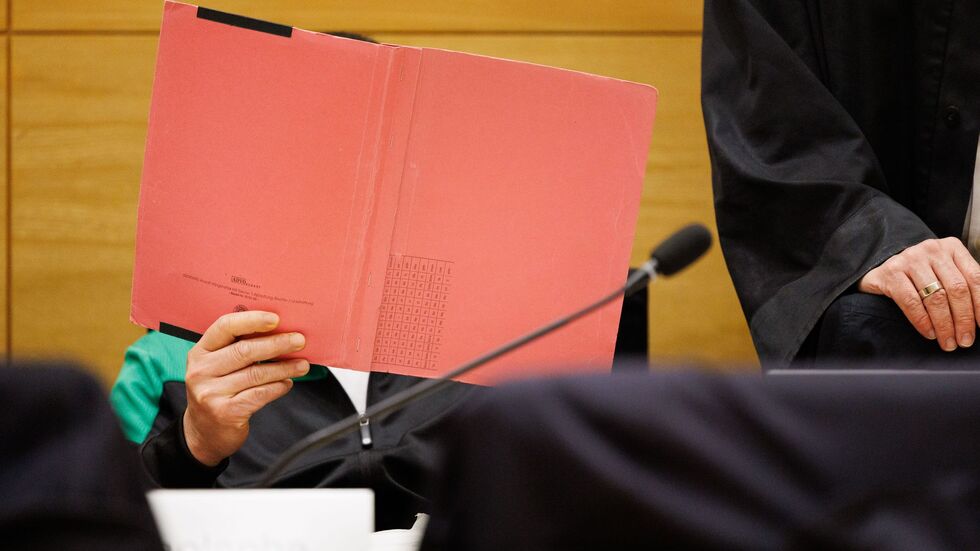 Einer der Angeklagten am Landgericht Bielefeld sitzt neben seinem Verteidiger und verdeckt sein Gesicht. Einer der Angeklagten am Landgericht Bielefeld sitzt neben seinem Verteidiger und verdeckt sein Gesicht.