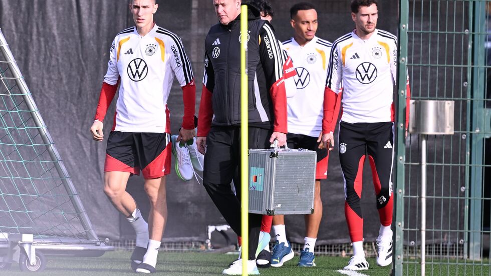 Mit Teamarzt Hahne (2.v.l.) betritt Schlotterbeck (l.) den Trainingsplatz. Mit Teamarzt Hahne (2.v.l.) betritt Schlotterbeck (l.) den Trainingsplatz.