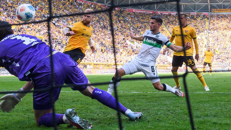 Nils Fröling (Dynamo Dresden, 2.v.l) erzielt gegen Torwart Nahuel Noll (Hannover 96) und Enzo Leopold (Hannover 96) das Tor zum 2:1. Nils Fröling (Dynamo Dresden, 2.v.l) erzielt gegen Torwart Nahuel Noll (Hannover 96) und Enzo Leopold (Hannover 96) das Tor zum 2:1.