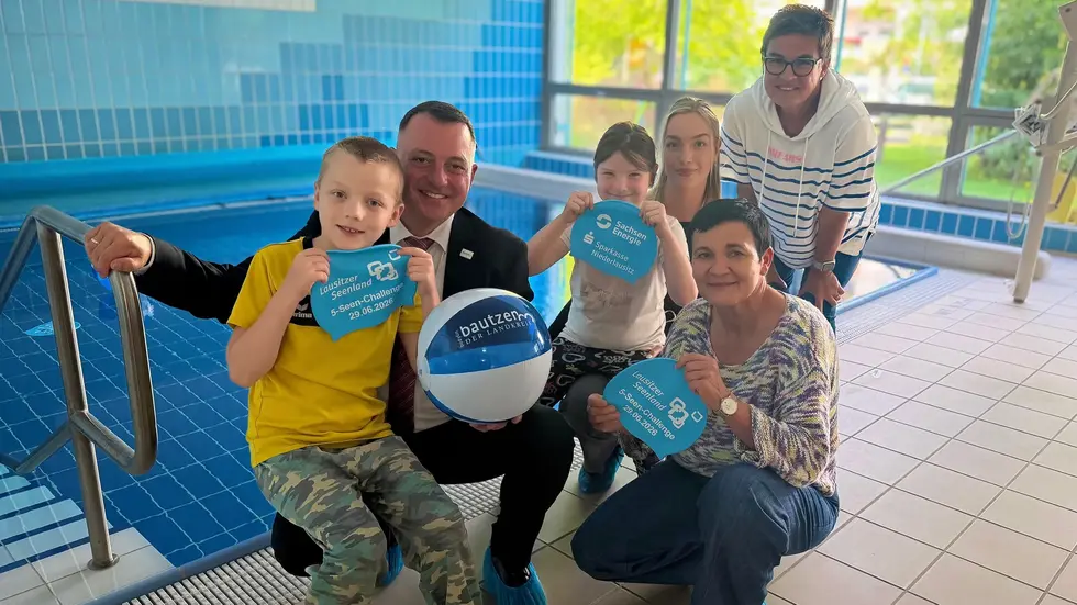 Stellvertretend für elf Förderschulen im Landkreis Bautzen nahm die Lindenschule Bautzen am 20. August 2026 die Badekappen entgegen. Auf dem Foto am Therapiebecken der Förderschule sind Schulleiterin Gundula Rabold (hinten rechts) mit zwei Schülern der Lindenschule sowie Landrat Udo Witschas, Kathrin Winkler (vorne rechts), Geschäftsführerin des Tourismusverbands Lausitzer Seenland e. V. und Therés Wurzler (Mitte), Projektkoordinatorin Netzwerk Barrierefrei im Lausitzer Seenland zu sehen. Mit der Spende erhalten die Badekappen der 5-Seen-Challenge einen nachhaltigen Nutzen für den Schwimmunterricht von Kindern und Jugendlichen mit Förderbedarf. Stellvertretend für elf Förderschulen im Landkreis Bautzen nahm die Lindenschule Bautzen am 20. August 2026 die Badekappen entgegen. Auf dem Foto am Therapiebecken der Förderschule sind Schulleiterin Gundula Rabold (hinten rechts) mit zwei Schülern der Lindenschule sowie Landrat Udo Witschas, Kathrin Winkler (vorne rechts), Geschäftsführerin des Tourismusverbands Lausitzer Seenland e. V. und Therés Wurzler (Mitte), Projektkoordinatorin Netzwerk Barrierefrei im Lausitzer Seenland zu sehen. Mit der Spende erhalten die Badekappen der 5-Seen-Challenge einen nachhaltigen Nutzen für den Schwimmunterricht von Kindern und Jugendlichen mit Förderbedarf.