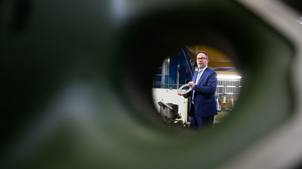 Wirtschaftsminister Dirk Panter besucht die MWK Defence GmbH in Königswartha, steht hinter einem Schwingarm für den Panzer Leopard 2