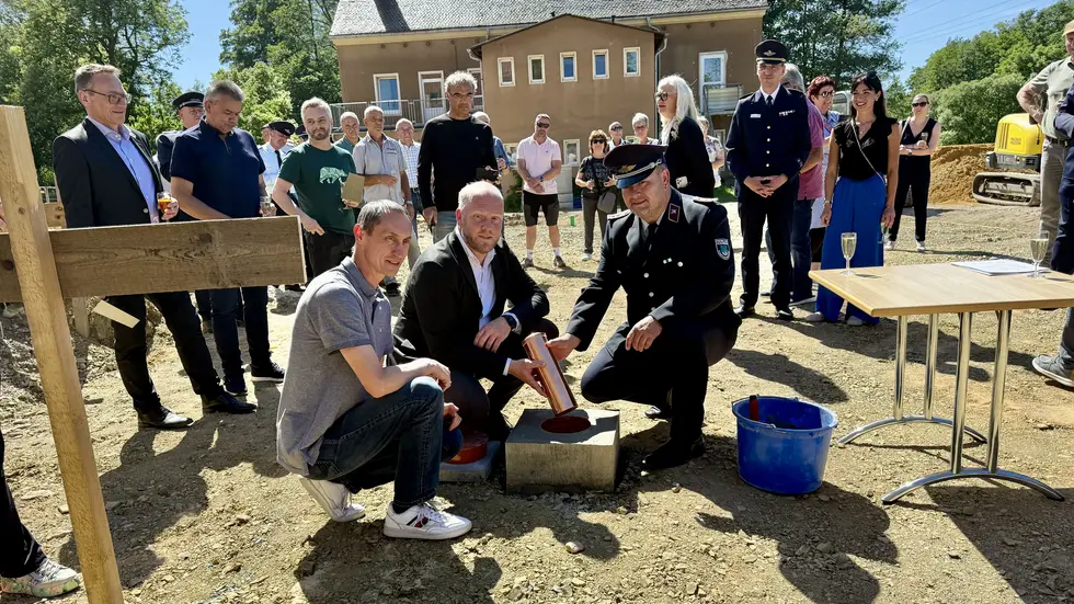 Eine kupferne Zeitkapsel wurde versenkt. Darin befinden sich u.a. eine aktuelle Tageszeitung (SZ) , eine Übersicht der aktiven Kameraden, der Förderbescheid, ein Foto vom alten Feuerwehrgerätehaus, ein Ärmelabzeichen der Wehr und eine kleine Flasche Jägermeister. Eine kupferne Zeitkapsel wurde versenkt. Darin befinden sich u.a. eine aktuelle Tageszeitung (SZ) , eine Übersicht der aktiven Kameraden, der Förderbescheid, ein Foto vom alten Feuerwehrgerätehaus, ein Ärmelabzeichen der Wehr und eine kleine Flasche Jägermeister.